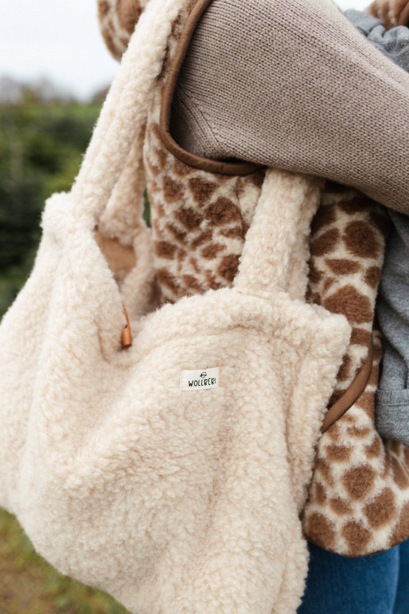 Frau trägt beige Mom Bag aus Schurwolle über dem Arm - Wollbebi